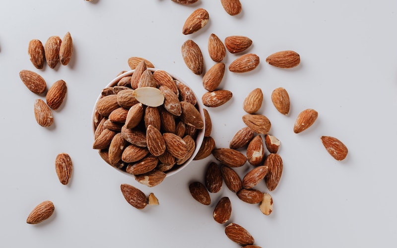 almonds in a bowl and on a white table